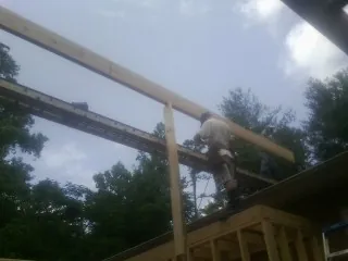 Carpenter setting a ridge beam over a new addition frame — Ice Dam Removal by Roofing Brothers in Hockingport