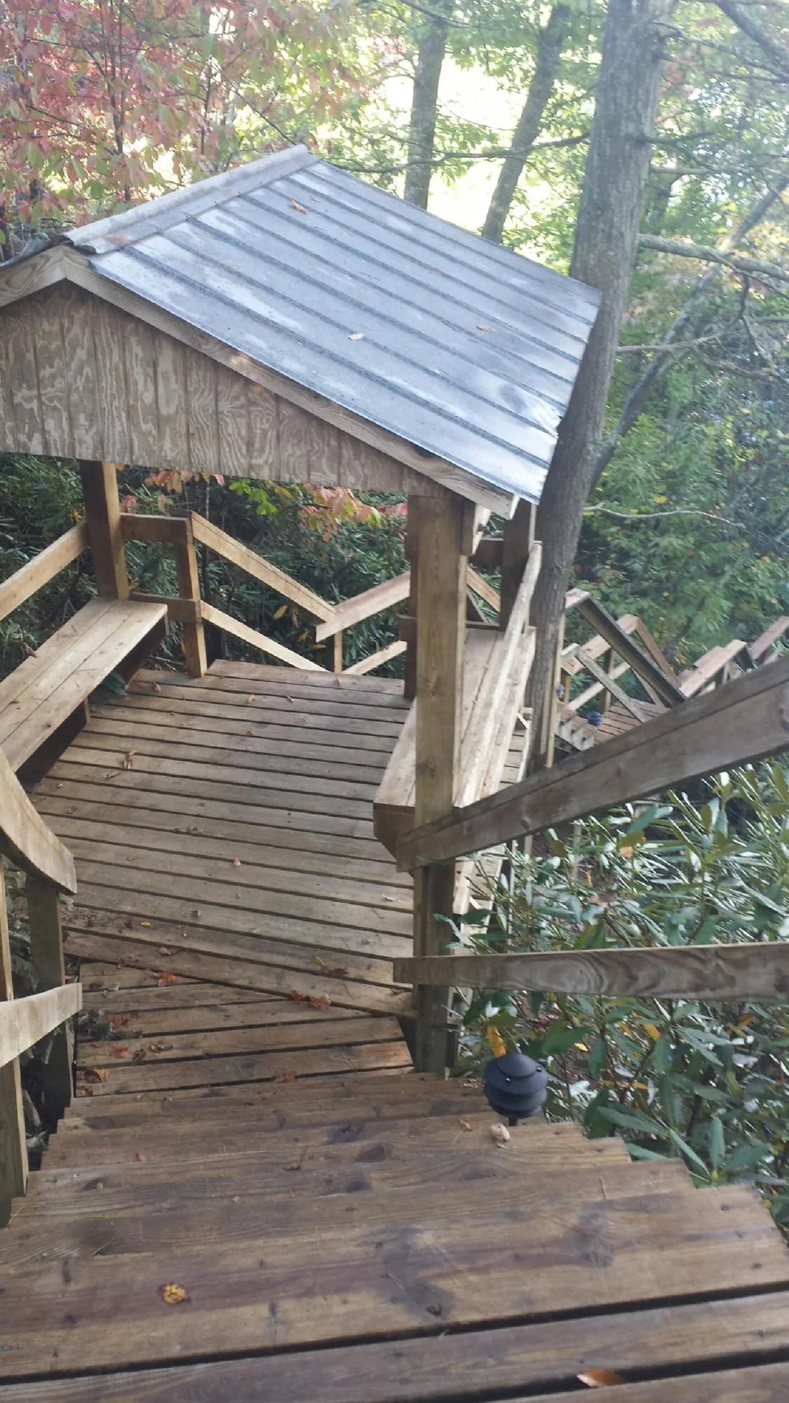 Metal roofed shelter over wooden steps on a wooded walkway — Skylight Repair & Installation work by our crew in Hockingport