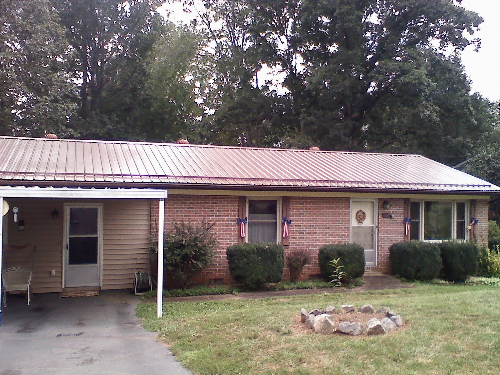Bronze metal roof and carport on a brick ranch home — Roof Repair work by our crew in Hockingport